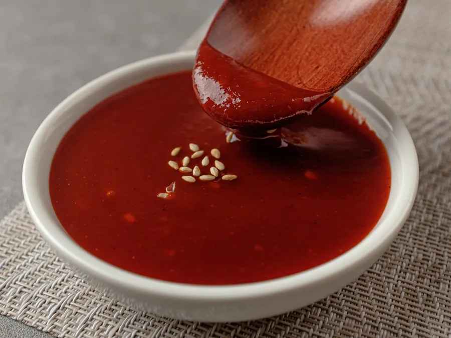 alt="Thin Korean gochujang sauce in a small dish"