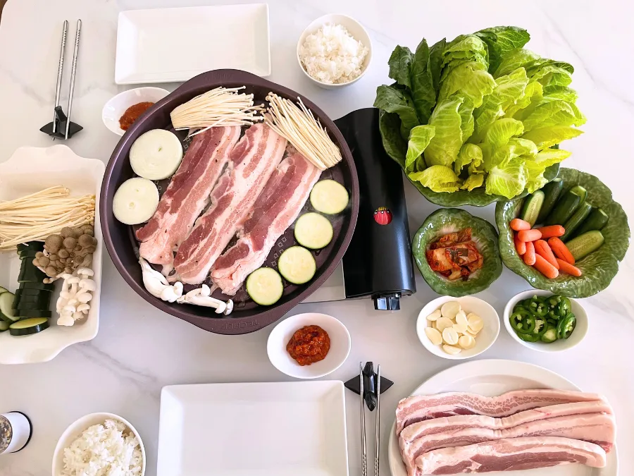 alt="Cabbage-shaped bowl set with lettuce wraps and samgyeopsal (pork belly) for Korean BBQ"