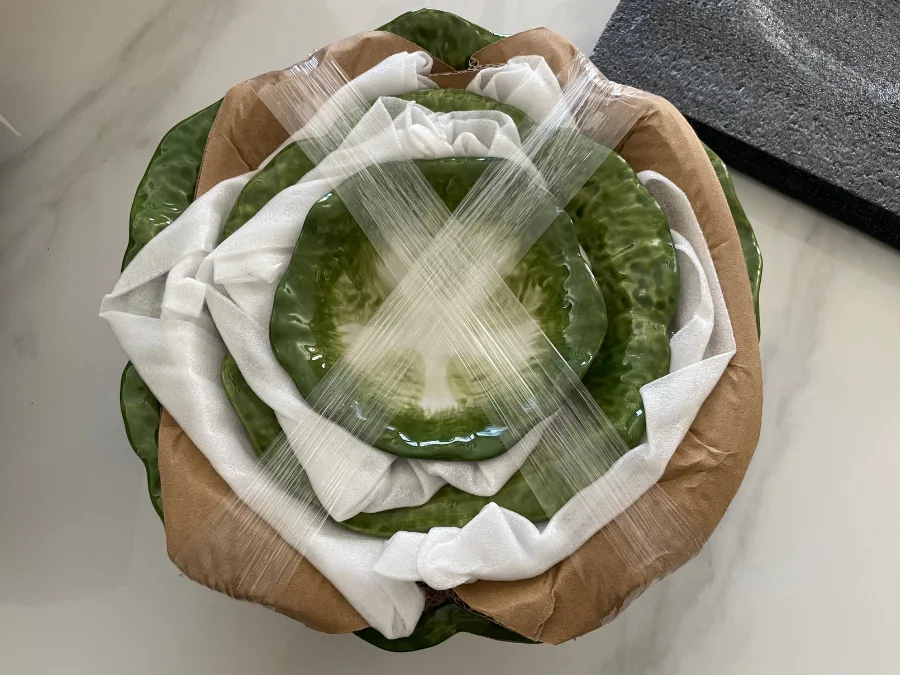 alt="Cabbage-shaped bowls neatly stacked and carefully packaged inside the box"
