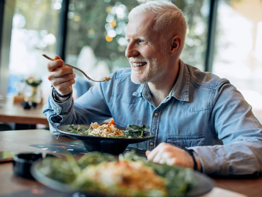 alt="An adult enjoying a meal at the table"
