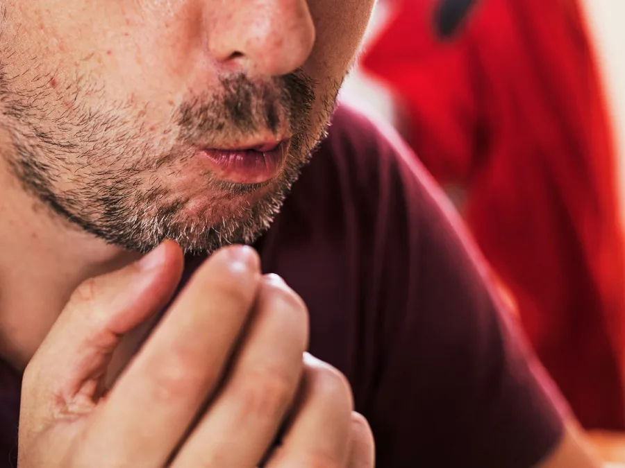 alt="Bearded man chewing on food"
