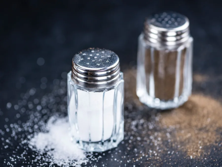 alt="Salt and black pepper in glass shakers"