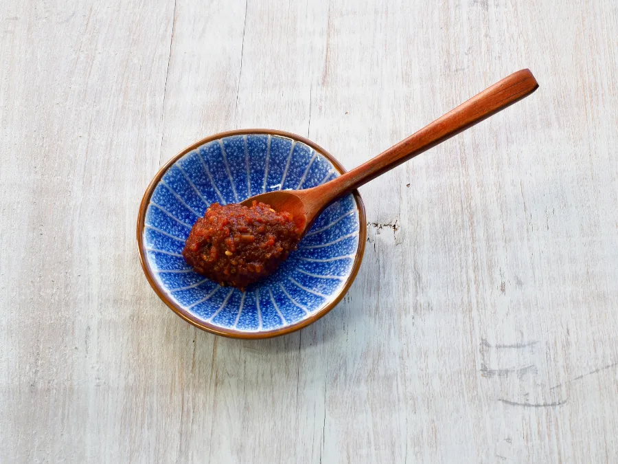alt="A spoonful of ssamjang in a beautiful blue dipping dish"