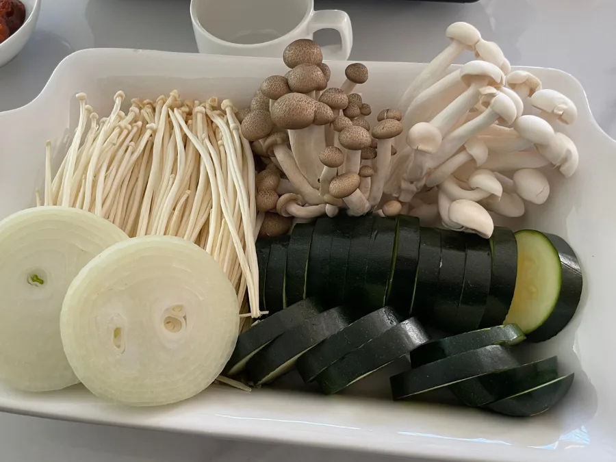 alt="Grilled zucchini, mushrooms, and onions served on a plate"